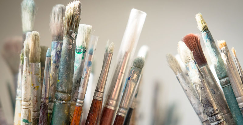A range of dirty paint brushes.